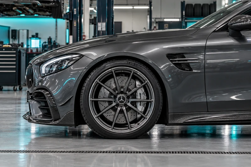 Mercedes AMG wheel, fender and side-skirt detail in a workshop