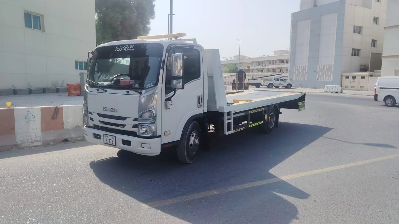 Flatbed recovery truck parked beside a road