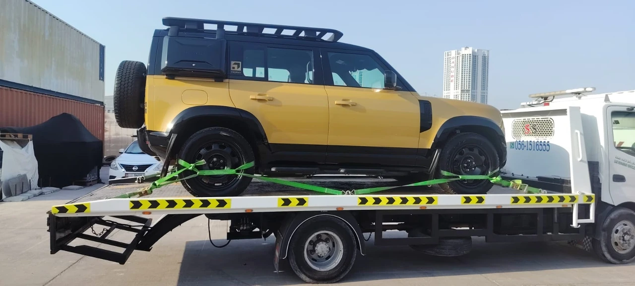 Yellow vehicle transported by a recovery truck
