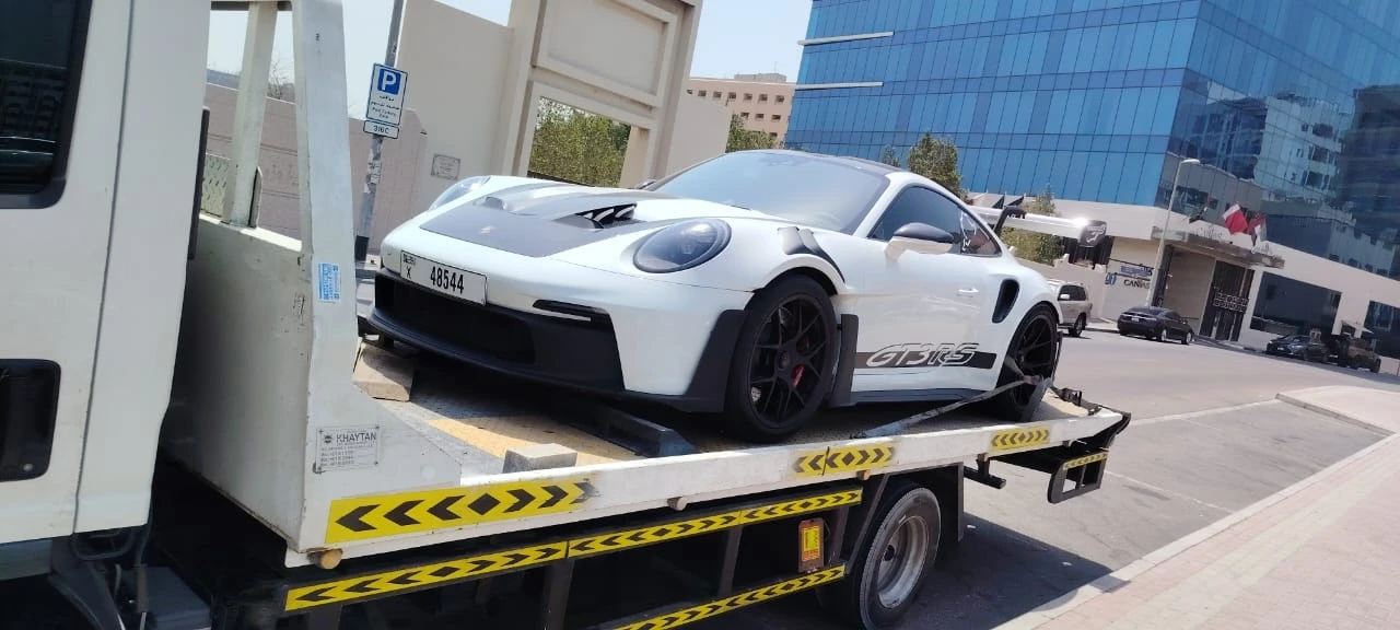 White sports car on a recovery truck