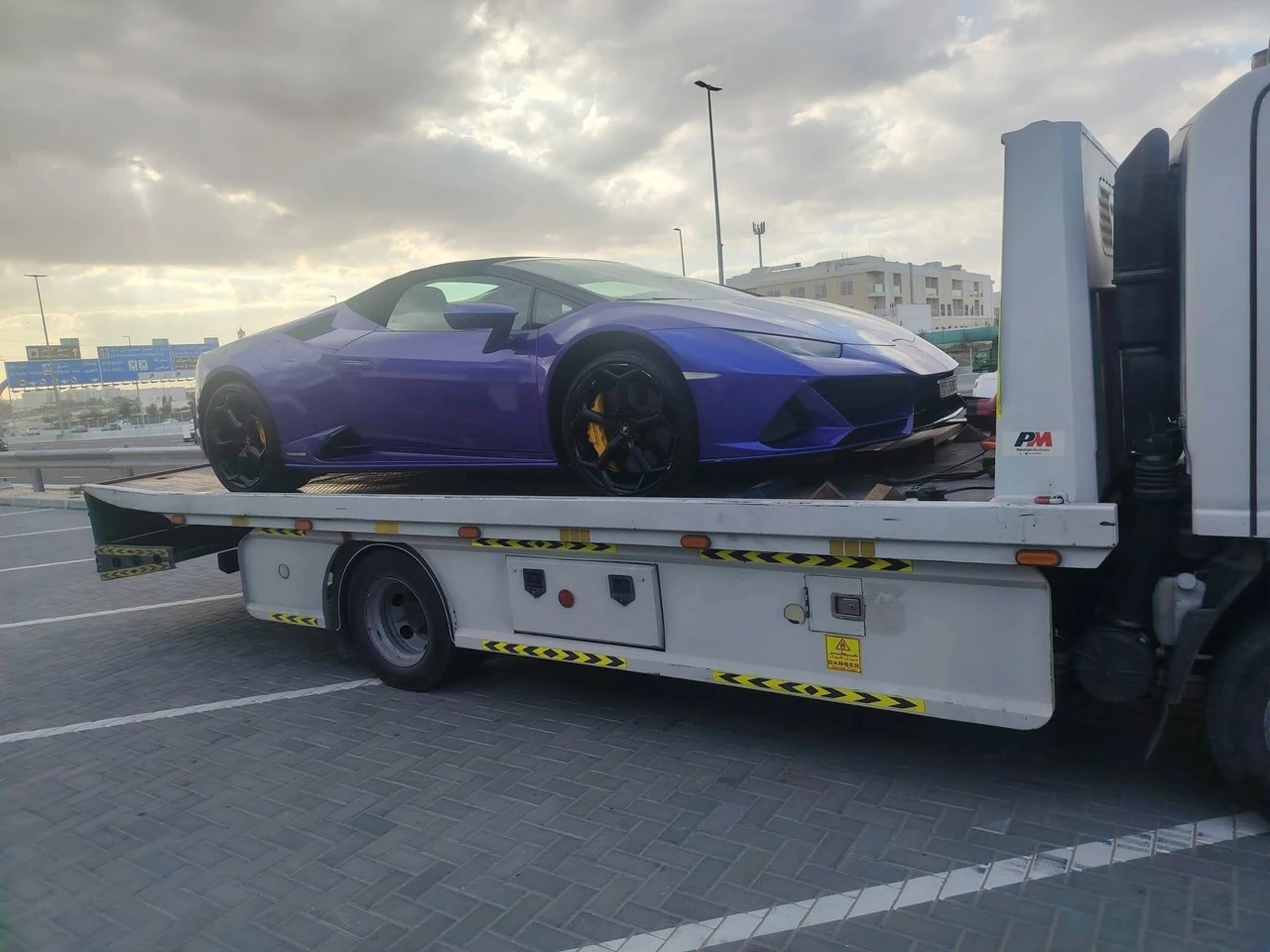 Blue sports car on a recovery flatbed