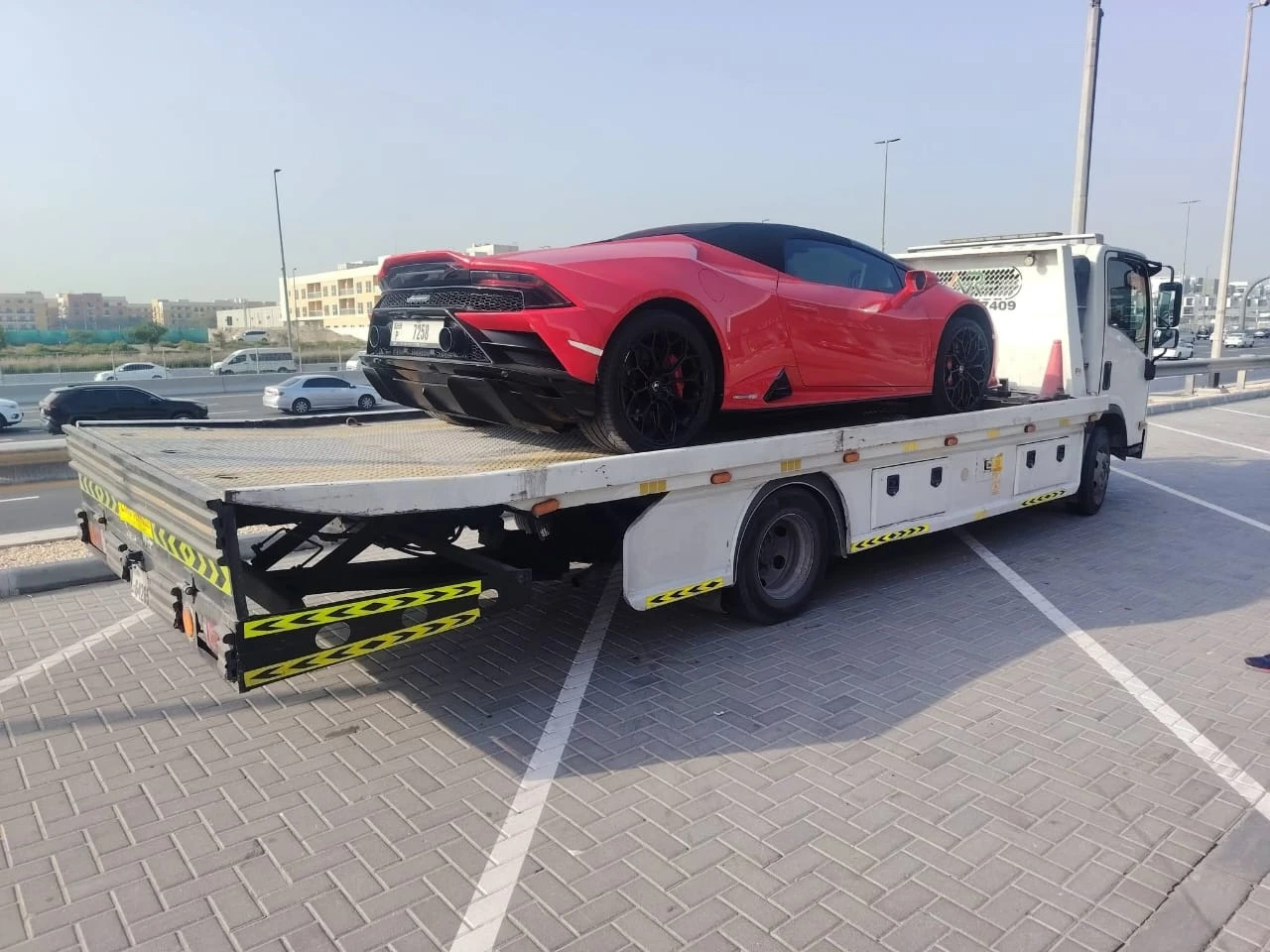 Red sports car on a flatbed recovery truck