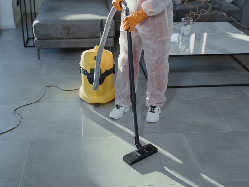 Dusting furniture and surfaces during a routine visit