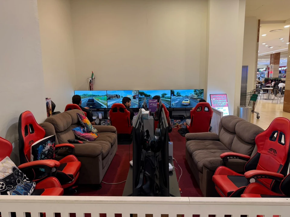 Full view of the PS Game Drive lounge with sofas, red gaming chairs and screens